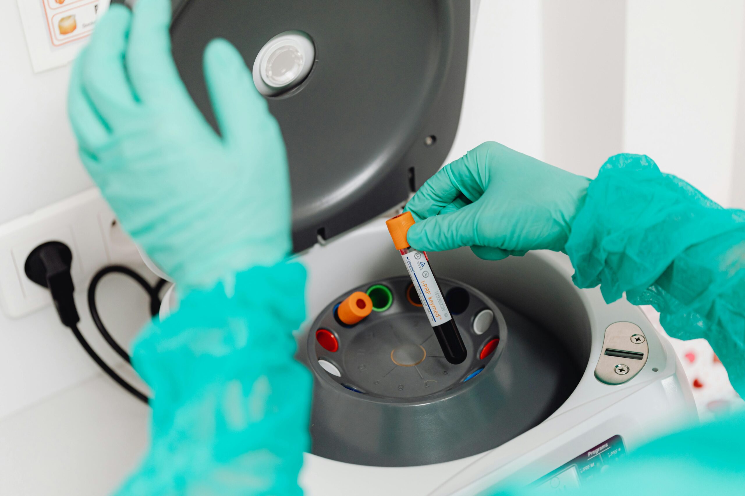 scientist loading centrifuge with vials of blood